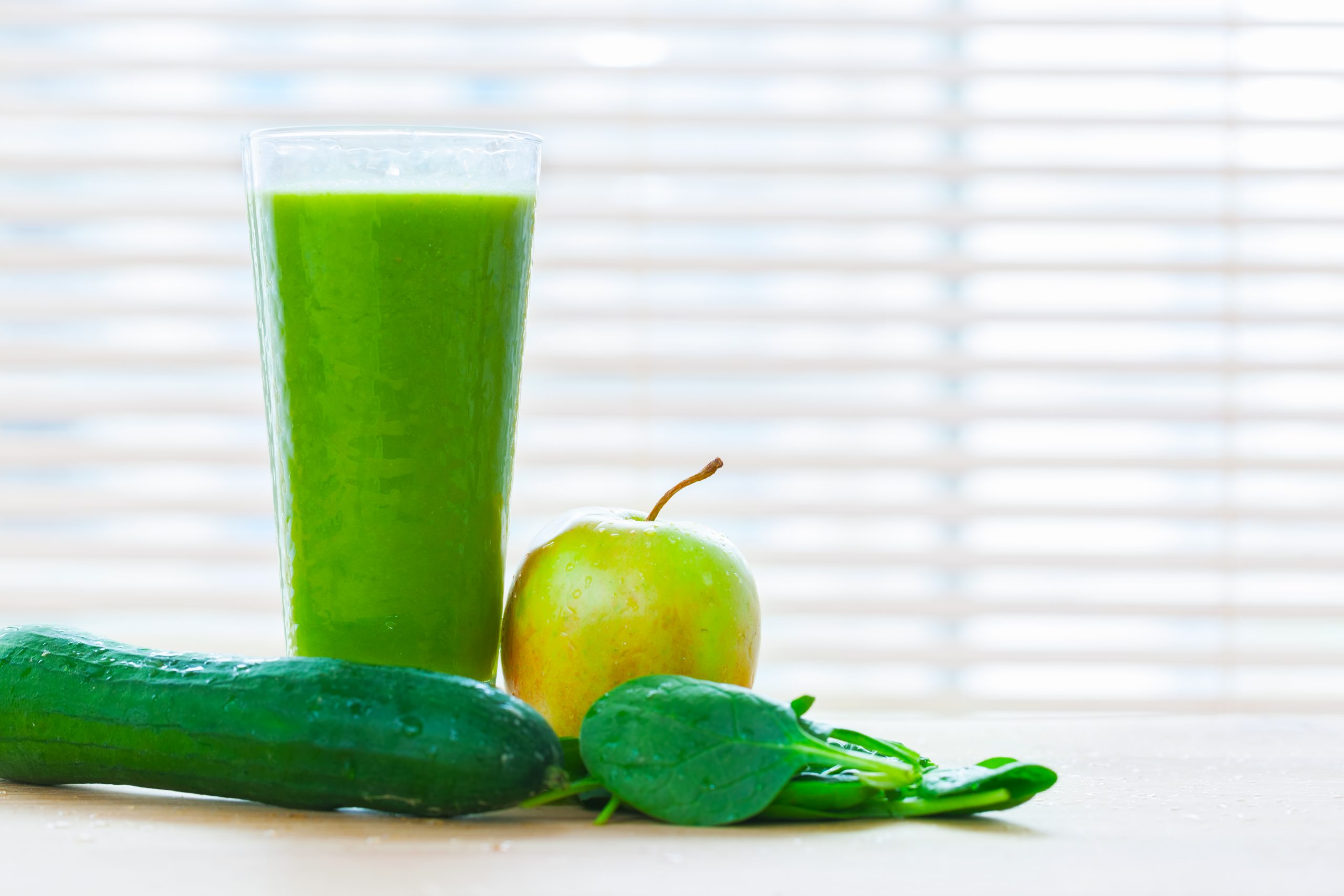 Fresh juice from green vegetables and fruits. Healthy organic and refreshing drink full of vitamins. Full glass with apple, cucumber and spinach leaves.